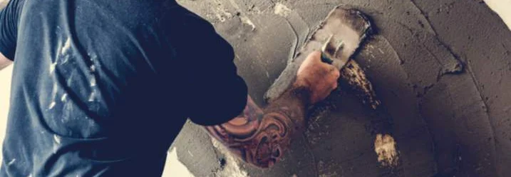 Person verputzt Wand mit Kelle